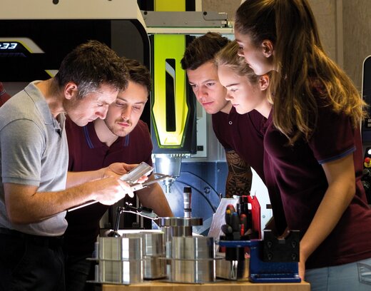 Auszubildender und Ausbilder arbeiten an einem Feinbohrer.